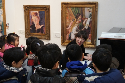 해운대문화회관 제 1전시실에 오르세미술관에 설치된 피아노치는 두 소녀 작품 앞에서 도슨트가 관람객들 앞에서 피아노를 치고 있다.