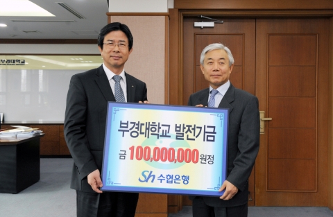 이주형 수협은행장(오른쪽)이 김영섭 부경대학교 총장(왼쪽)에게 부경대학교 발전기금식에서 기념사진을 찍고 있다.