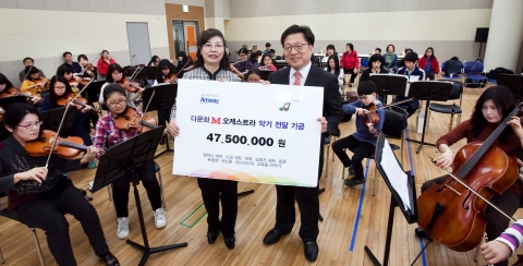 한국암웨이가 다문화 M오케스트라의 연습실을 찾아 악기 기금을 전달하고, 기념 촬영을 하고 있다. (좌측부터 다문화 M오케스트라 김유정 단장, 한국암웨이 노원호 상무)