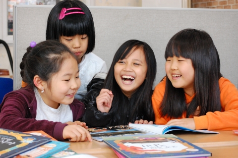 안산다문화학교 어린이들이 한솔수북의 열린 마음 다문화 책을 보며 즐거워하고 있다.