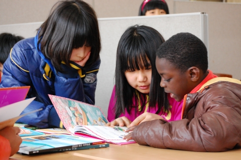 안산다문화학교 어린이들이 한솔수북의 열린 마음 다문화 책을 보며 즐거워하고 있다.