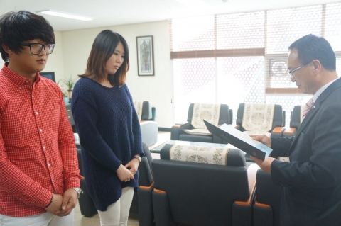 허진유 지점장이 패션마케팅과 2학년 진선영, 패션소재과 2학년 박화서 학생에게 장학금을 전달하고 있다.