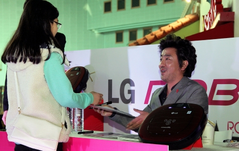 16일 롯데월드에서 열린 LG전자 로봇청소기 로보킹 행사에서 로보킹 광고모델 배우 류승룡이 고객에게 사인을 해주고 있다.