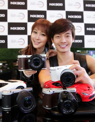 삼성전자는 하이브리드 오토 포커스 등 다양한 기능을 탑재한 스마트 카메라 ‘NX300’을 국내 시장에 출시한다고 20일 밝혔다. 사진은 삼성전자 모델이 서울 서초동 삼성전자 딜라이트숍에서 신제품 ‘NX300’을 선보이는 모습이다.