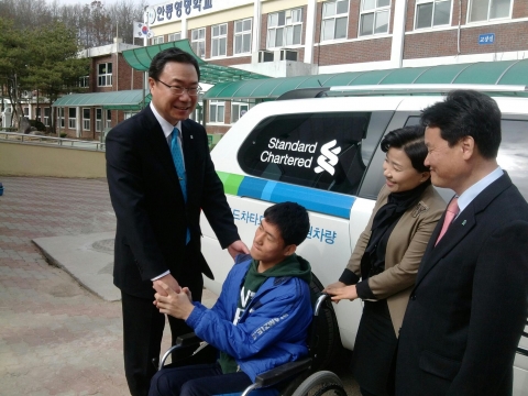 차량기증식에서 안동영명학교 재학생과 반갑게 인사를 나누는 스탠다드차타드은행 임직원들 (좌로부터 임광현 영남/강원소매사업부 상무, 김애란 안동지점장, 김영철 경북강원지역본부 이사)