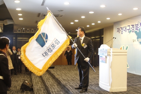 대경포럼 발대식에서 최진국 회장이 대경포럼 깃발을 들고 있다