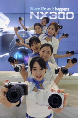 4월 4일~7일까지 삼성동 코엑스에서 열리는 ‘제22회 서울국제사진영상기자재전’에서 삼성전자 모델들이 지난 3월말에 출시된 차세대 미러리스 카메라 ‘NX300’을 선보이고 있다.