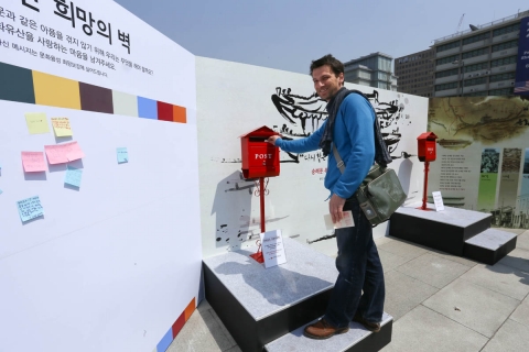 광화문 광장에 설치된 희망우체통에 희망엽서를 넣고 있는 외국인.