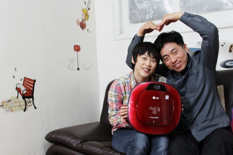 LG전자에서 진행한 가족을 위한 단 하나의 로보킹 이벤트에서 사연 당첨자인 황규석씨가 아내와 함께 로보킹을 들고 즐거워하고 있다.