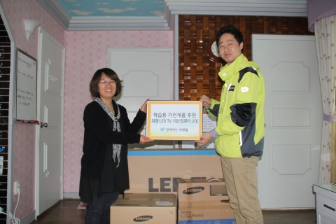 함께하는 사랑밭 관계자가 아동시설 해피홈에 어린이날 선물을 전달하고 있다.