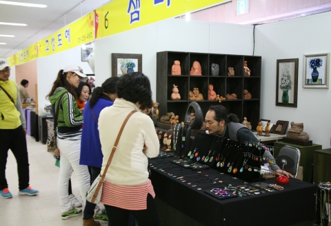 여주도자기한마당에서 도자기로 만든 목걸이와 브로치 등 장신구를 고르는 여성 관람객들