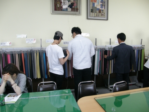 신한화섬 전시룸에서 제작된 섬유원단을 살펴보고 있다.