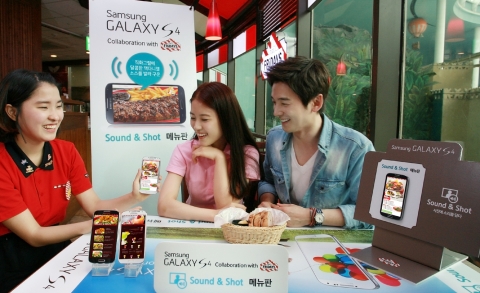T.G.I FRiDAY'S 잠실점에서 고객들이 사운드앤샷 기능을 통해 갤럭시 S4로 메뉴를 고르고 있다.
