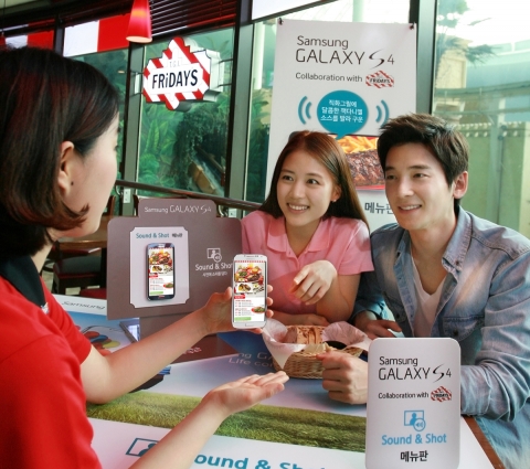 T.G.I FRiDAY'S 잠실점에서 고객들이 사운드앤샷 기능을 통해 갤럭시 S4로 메뉴를 고르고 있다.