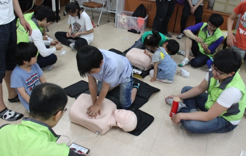 대구사회복무교육센터 봉사동아리인 행복한 동행이 아이들에게 심폐소생술을 가르치고 있다.