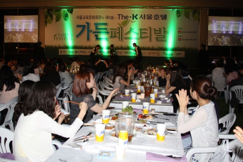야외에서 맥주와 뷔페 그리고 공연을 즐기는 관객