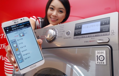 LG전자가 국내 세탁기 최초로 NFC 기능을 탑재한 트롬 스마트 세탁기를 출시한다. 모델이 제품 앞에서 직접 스마트폰으로 NFC 기능을 시연하고 있다.