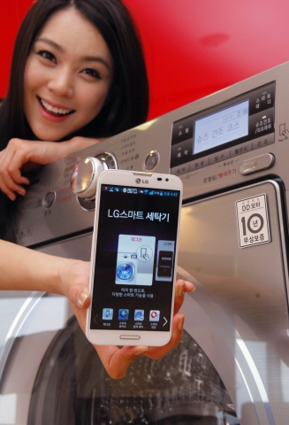 LG전자가 국내 세탁기 최초로 NFC 기능을 탑재한 트롬 스마트 세탁기를 출시한다. 모델이 제품 앞에서 직접 스마트폰으로 NFC 기능을 시연하고 있다.