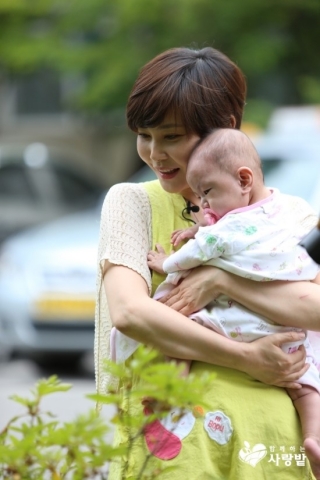 사단법인 함께하는 사랑밭 홍보대사인 배우 추상미 난치병 아기의 일일 엄마로 아기를 안고 있다.