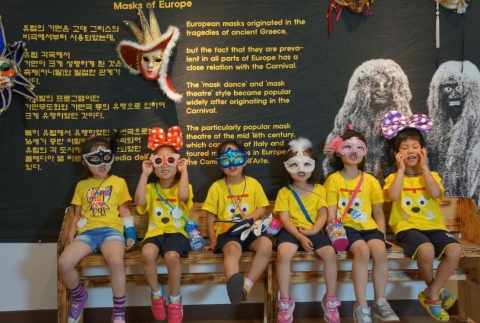 양산문화예술회관 전시실에 관람온 유치원생들이 유럽의 가면앞에서 가면을 쓰고 사진을 찍고 있다.