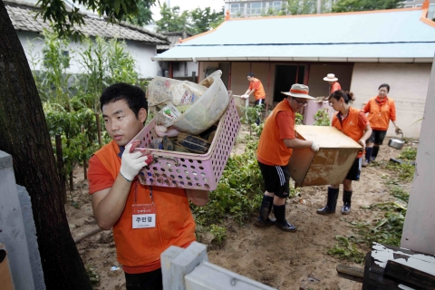 한화그룹 신입사원들이 17일 강원도 춘천시 퇴계동에서 폭우로 침수된 가구를 찾아 복구작업을 하고 있다.