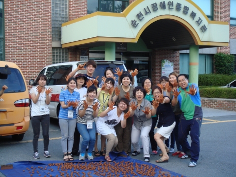 복지관 직원들이 함께 em흙공을 만든 다음 단체사진 촬영을 하고있다.