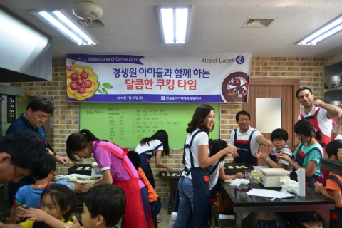 전 세계 자원 봉사의 날을 맞아 한국 알카텔-루슨트 임직원들이 아동복지시설 경생원 아이들과 쿠킹 클래스에 참여해 과자를 만들고 있다. (오른쪽 테이블 중앙에 유지일 사장)