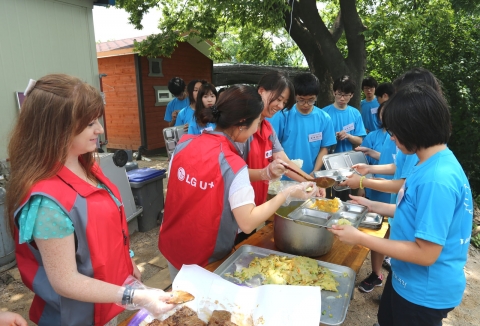 LG유플러스(부회장 이상철)와 사회복지법인 우리누리는 서울 성북구에 위치한 개운산 무료급식소에서 배식봉사와 휴대폰 활용법 안내 활동을 펼쳤다. 사진은 청소년과 LG유플러스 직원이 배식 봉사를 하고 있는 모습.