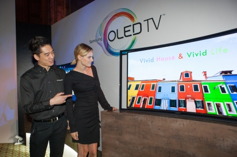 13일(현지시간) 뉴욕 맨해튼에서 열린 삼성 커브드 OLED TV 미국 미디어데이에서 삼성전자 직원이 관람객에게 커브드 OLED TV를 소개하고 있다.