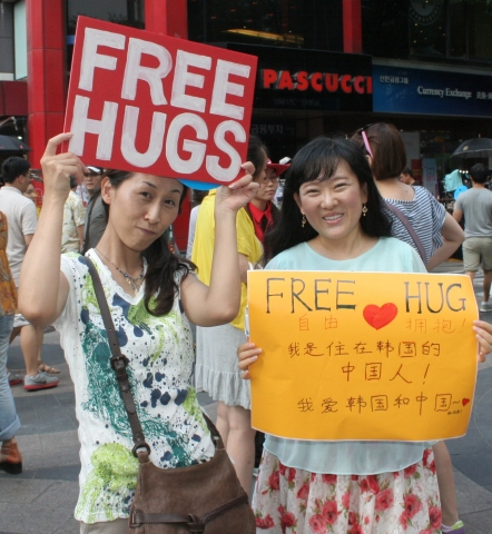 16일 명동에서 함께 프리허그를 하는 일본여성,중국여성