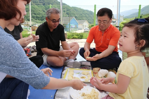 한국후지제록스 우에노 야스아키 사장(오른쪽에서 세 번째)이 8월 24일 강원도 화천에 위치한 장애인 복지관 ‘사랑이 꽃피는 집’에서 추석을 앞두고 복지관 식구들과 송편을 빚고 있다