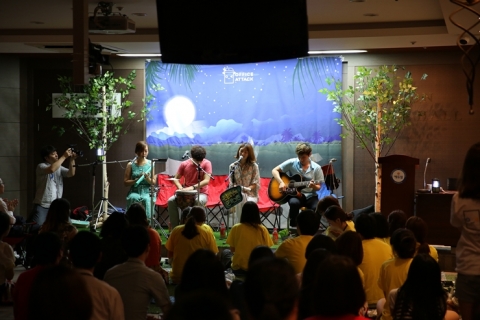 에듀윌 임직원들이 어쿠스틱 밴드 공연을 보며 캠핑장에 온 것처럼 즐거워하고 있다.