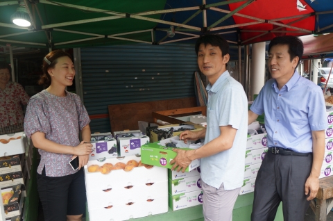 조형준 과장이 과일상점에서 포도를 구매하고 있다.
