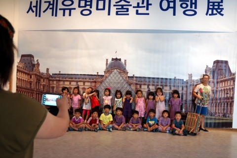 창녕문화예술회관 전시실에서 개최중인 세계유명미술관 여행展에서 유치원생들이 루브르박물관앞에서 기념사진을 찍고 있다.