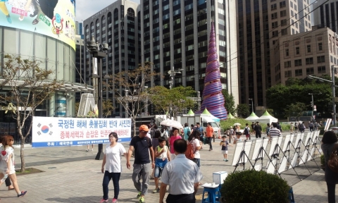 애국주의연대가 지난 8월 28일 오후 청계광장 동아일보 사옥앞에서 국정원 해체 촛불집회 반대 사진전을 개최하고 있다.