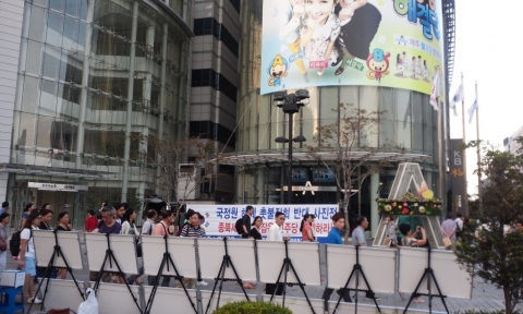 애국주의연대가 지난 8월 28일 오후 청계광장 동아일보 사옥앞에서 국정원 해체 촛불집회 반대 사진전을 개최하고 있다.