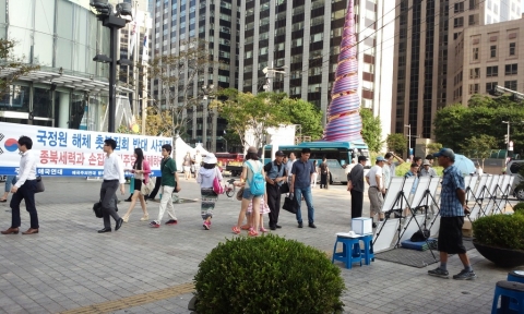 애국주의연대가 지난 8월 28일 오후 청계광장 동아일보 사옥앞에서 국정원 해체 촛불집회 반대 사진전을 개최하고 있다.