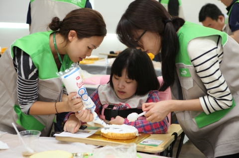 초록우산 어린이재단 직원들이 아동들과 함께 케잌 만들기를 하며 즐거운 시간을 보내고 있다.