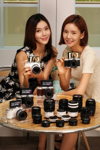 삼성전자가 삼성 미러리스 카메라 최초로 180°회전하는 디스플레이를 채용한  스마트 카메라 NX300M을 7일 국내 시장에 선보인다. 사진은 삼성전자 모델들이 스마트 카메라 NX300M을 소개하는 모습.