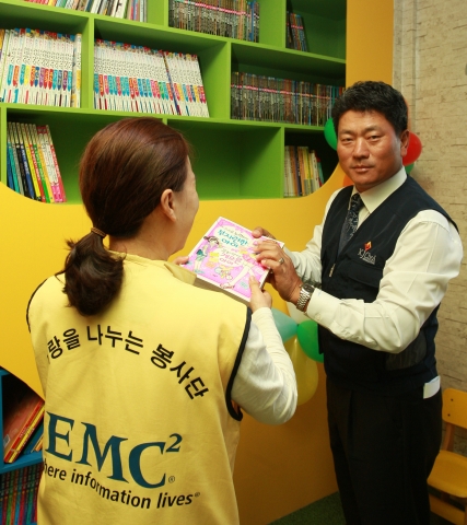 한국EMC 임직원 및 최경주 재단 자원봉사자들이 꿈의 도서관 건립을 위해 책장을 정리하고 있다.
