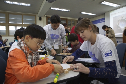 신한카드 임직원들이 10월 19일 서울 정동에서 열린 아름人 문화共感 프로젝트 - 다문화 가정과 함께하는 서울 문화 답사 행사에서 다문화 가정 참가자들과 함께 소목(小木)공예 체험을 하고 있다..