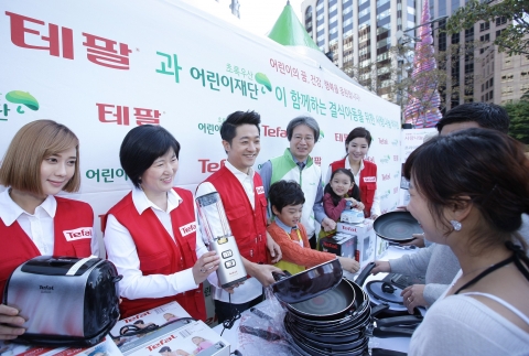 10월 22일, 동아일보사 앞에서 진행된 ‘테팔 결식아동을 위한 사랑 나눔 바자회’에 테팔 임직원들과 가수 알렉스가 직접 참여해 바자회 제품을 판매하고 있다.