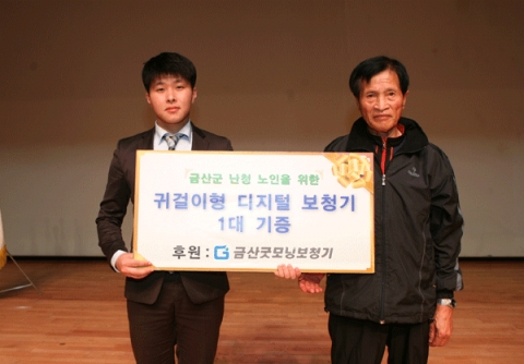 금산굿모닝보청기 최성대 대표가 제 17회 노인의 날 기념식에서 난청 어르신께 보청기를 전달하고 있다.