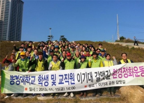 동명대의 설동근 총장 학생 교수 직원 등이 함께 이기대 갈맷길 환경정화 봉사활동을 하고 있다.