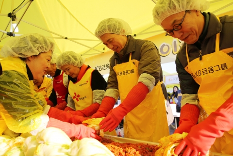 임영록 KB금융그룹 회장, 이건호 KB국민은행장이 참석자들과 함께 김장을 담구고 기념촬영을 하고 있다