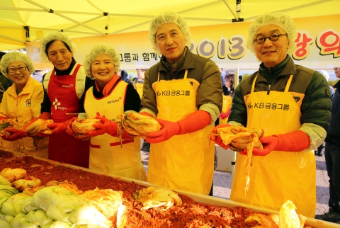 임영록 KB금융그룹 회장, 이건호 KB국민은행장이 참석자들과 함께 김장을 담구고 기념촬영을 하고 있다