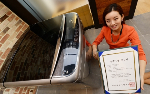 서울 여의도 소재 LG트윈타워에서 여성 모델이 LG 세탁기의 터보샷 기술로 받은 녹색기술 인증서를 소개하고 있다. 제품은 이 기술을 적용한 LG 블랙라벨 세탁기다.