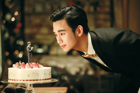 본인과 꼭 닮은 피규어가 올라간 케이크를 바라보고 있는 김수현