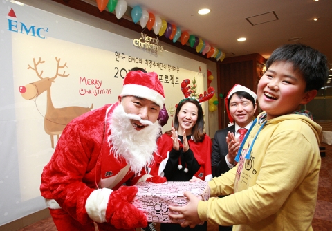 산타 옷을 입은 한국EMC 임직원들이 미리 준비한 성탄 선물을 아이들에게 전달하고 있다
