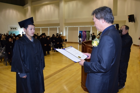 박만균 학장이 학생대표에게 학위증서를 수여하고 있다.